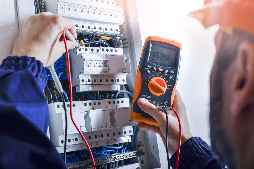 Multimeter in hands of electricians detail.